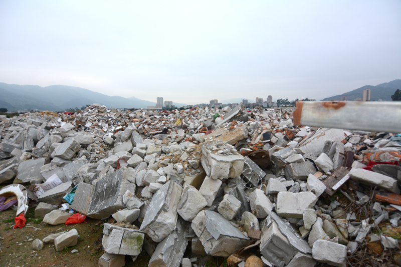 过江片河道和大片农田被建筑垃圾填埋现场.