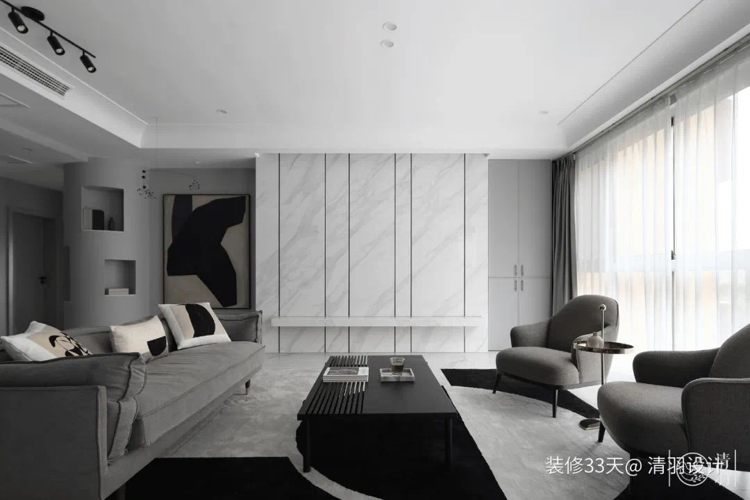 布置灰色布艺沙发,搭配不规则色块的地毯和深色木质茶几,赋予空间