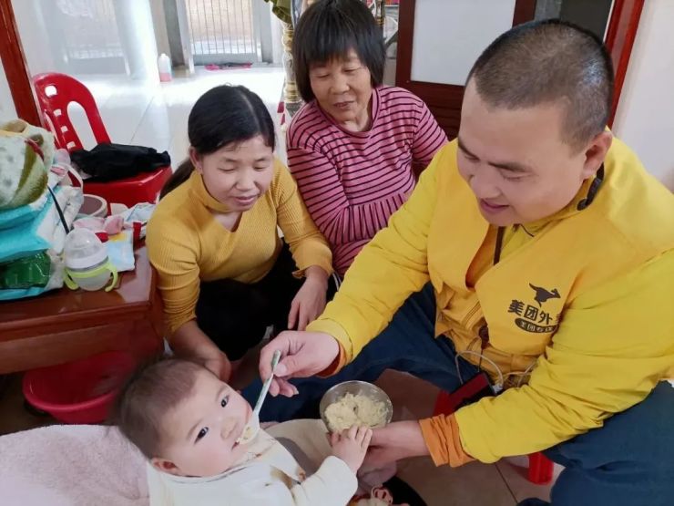 陈龙生和母亲、妻子在给孩子喂饭